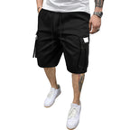 Person wearing black cargo shorts and white sneakers against a gray background