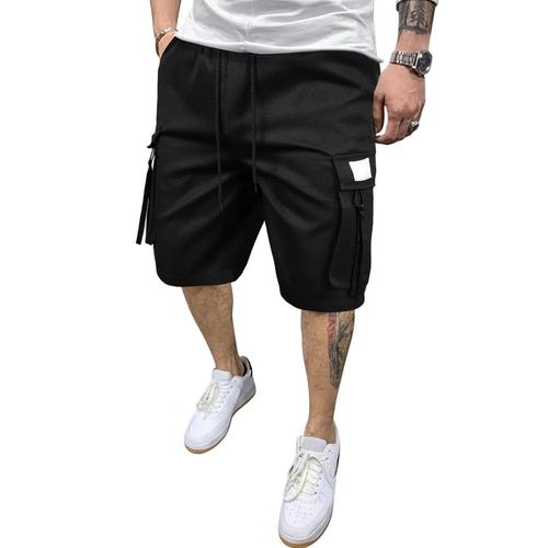 Person wearing black cargo shorts and white sneakers against a gray background