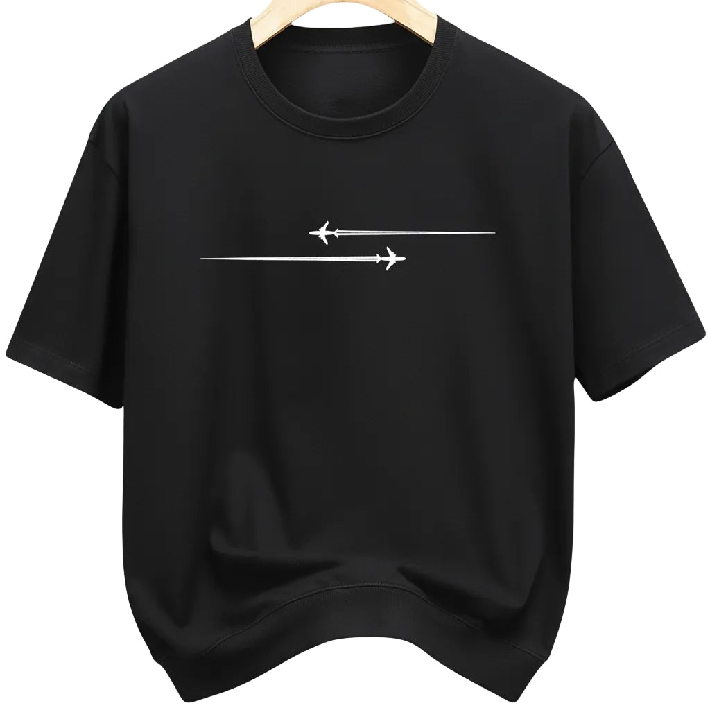 Black t-shirt with white airplane design on a hanger in a clothing store.