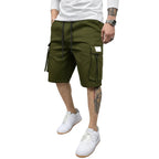 Person wearing green cargo shorts and white sneakers against a gray background