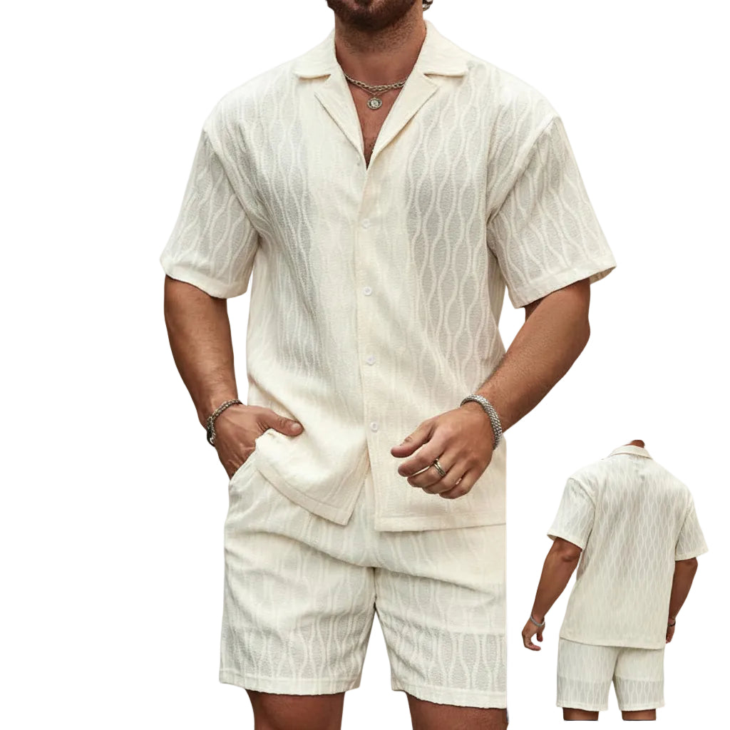 Man wearing a beige linen shirt and shorts set against a stone wall.